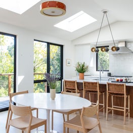 Combined kitchen and dining area with white pedestal table
