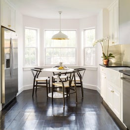 Hamptons Kitchen with black floors and breakfast table at bay windows 