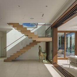Sculptural floating stair and sliding glass in an oceanfront modern beach house