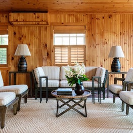 Rustic wood paneled walls in this neutral family room with mid century furnishings.