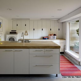 Sleek laundry room with wooden counter top