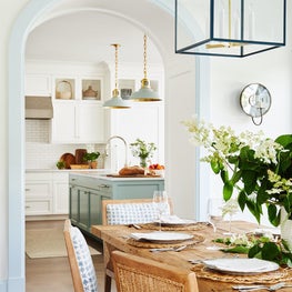 Blue and white dining room and kitchen with hanging lanterns and pendants
