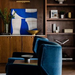 Portfolio: Elegant blue accent chairs and bookshelf with decorations in living room