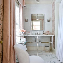 At Home toiletry area with marble floors, pink drapes