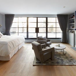 Spacious townhouse bedroom with original fireplace and industrial steel windows