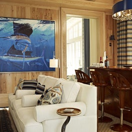 This room has expansive windows that open out to the pool terrace which offers the feeling of being on a yacht. A custom bar made of a marine-varnished mahogany in the game room. 