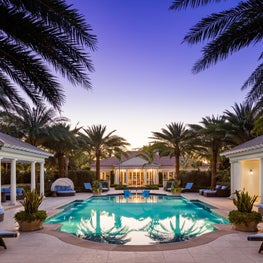 Pool pavilions flanking a pool and framing a view of the pool house.