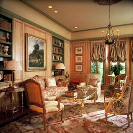 Formal living room with ornate wall paneling and molding. 