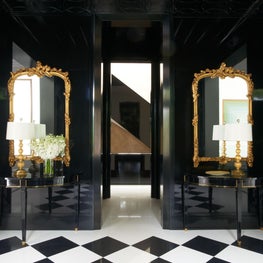 The black lacquered foyer provides a dramatic entrance. Featured in Veranda.