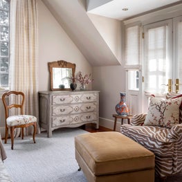 Bedroom w Swedish dresser, grey divan, camel zebra arm chair, hide ottoman