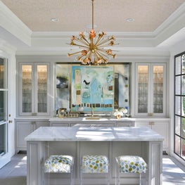 Renovated bar with steel doors, wallpaper ceiling, brass accents & lucite detail