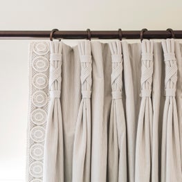 Drapery pleats laced like riding boots and trimmed in crochet 