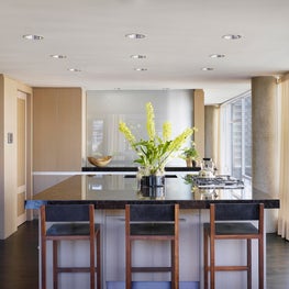 Sand-colored wooden walls, rift oak & Emperador marble island & BDDW bar stools 
