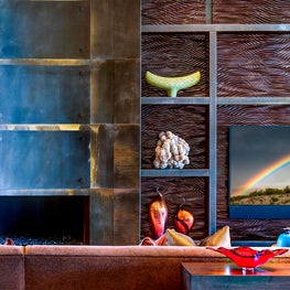 The deep wave contours on the adjoining TV wall gives the fireplace even more dimension