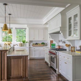 Kitchen with Subway Tile, Marble Counter Tops, Brass Hardware and Wood Flooring