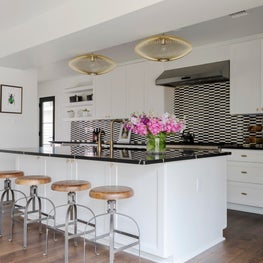 Renovated Kitchen with black and white marble backsplash and brass accents 