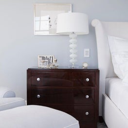 Dark wood furniture adds gravitas to the soft-hued space.