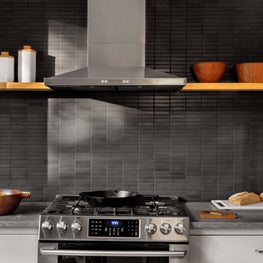 Kitchen with open shelving, black stone backsplash