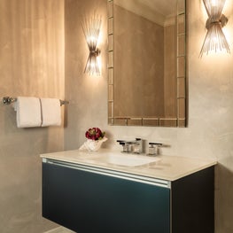 A serene neutral palette bathroom with a floating vanity and glamorous sconces.