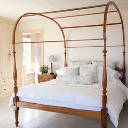Upstate NY farmhouse, master bedroom with wooden canopy bed & wide plank floors.
