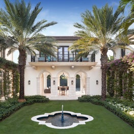 A view through the Tennis House to the court at an oceanfront Palm Beach Estate