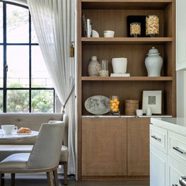 Portfolio: An elegant breakfast nook with sheer drapery and black-framed window.