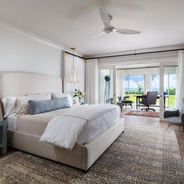 This master bedroom is surrounded with a pastel palette and an abundance of natural light.
