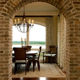 Dining Room through a Brick Arched Opening to a River and Marsh View