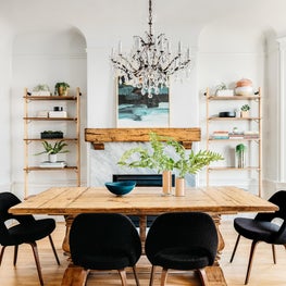 Rustic eclectic dining room with mid-century chairs and crystal chandelier.