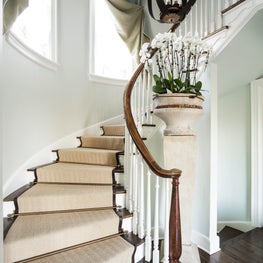 Grand staircase with leather bound sisal runner and architectural fragments