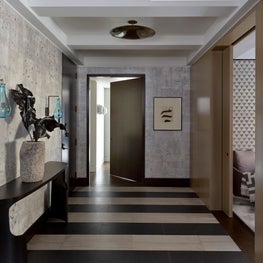 Graphic entrance gallery with custom wallpaper and glass sconces