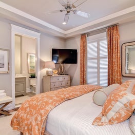 Guest bedroom with orange bedding and window treatments