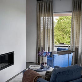 Subdued colors, subtle texture, and sophisticated layers make this primary suite a sensual and spa-like retreat for the homeowners.