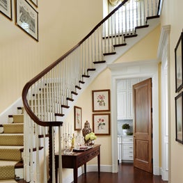 A classic stairway with wood a banister flows from the downstairs to upstairs..
