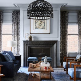 Warm and sophisticated soft blue living room with wooden armchairs