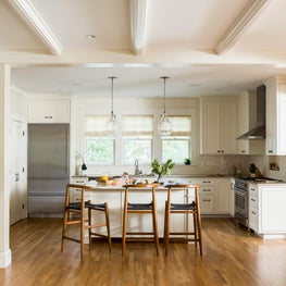 Kitchen and great room w modern stools and glass pendants