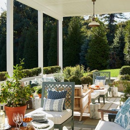 Outdoor terrace with green and white outdoor furniture and ceiling fixtures