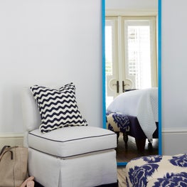 Turquoise standing mirror, slipper chair and bold navy pattern