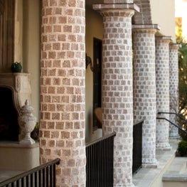 Round Brick Column Loggia with Brick Arches and Black Metal Railing