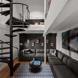 Grey & white modern lounge with spiral staircase, large sale art