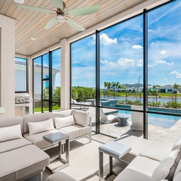 Palm Beach Sleek Contemporary - Indoor/outdoor sunroom and patio with opening window walls. Neutral colors, luxurious textiles