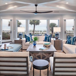 A clean, coastal living room with pops of darker blues