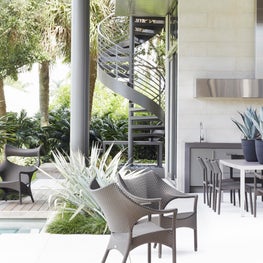 Sleek, outdoor, poolside kitchen and patio with contemporary seating