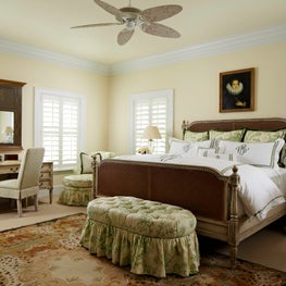 A neutral French inspired bedroom enhanced with patterned upholstered seating.