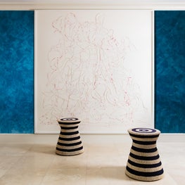 Organic sisal garden stools from Palecek contrast large modern blue & white art.