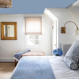 Bedroom with wool plaid bench, swing arm sconces, blue painted ceiling