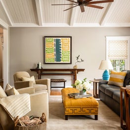 Modern Family Room with mustard leather colored ottoman, suede club swivel chairs, altar table