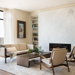 Modern Scandinavian living room with organic coffee table and marble fireplace