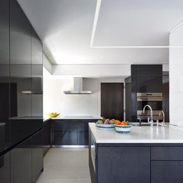 Minimal kitchen with Bulthup cabinetry and stone floors.