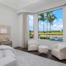 Expansive Decadent Waterfront, master bedroom, lucite furniture, lucite lamp, picture window, upholstered headboard, neutral bedroom